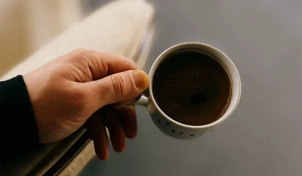 a person is holding cofee cup